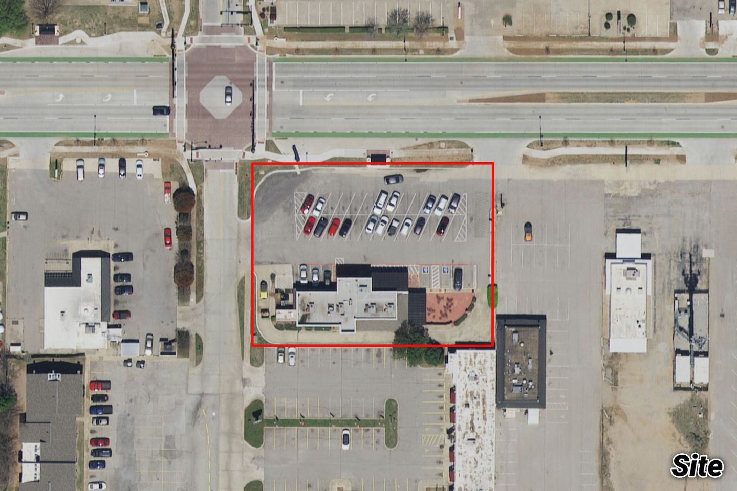 Aerial of the small building-and-parking parcel outlined in red at a Lindsey Street intersection, near homes and an existing retail strip.