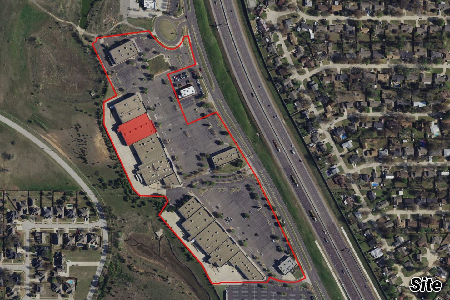 Aerial of the Parkway Plaza shopping center along I-35 with the Jo-Ann Fabrics space highlighted by its red roof.
